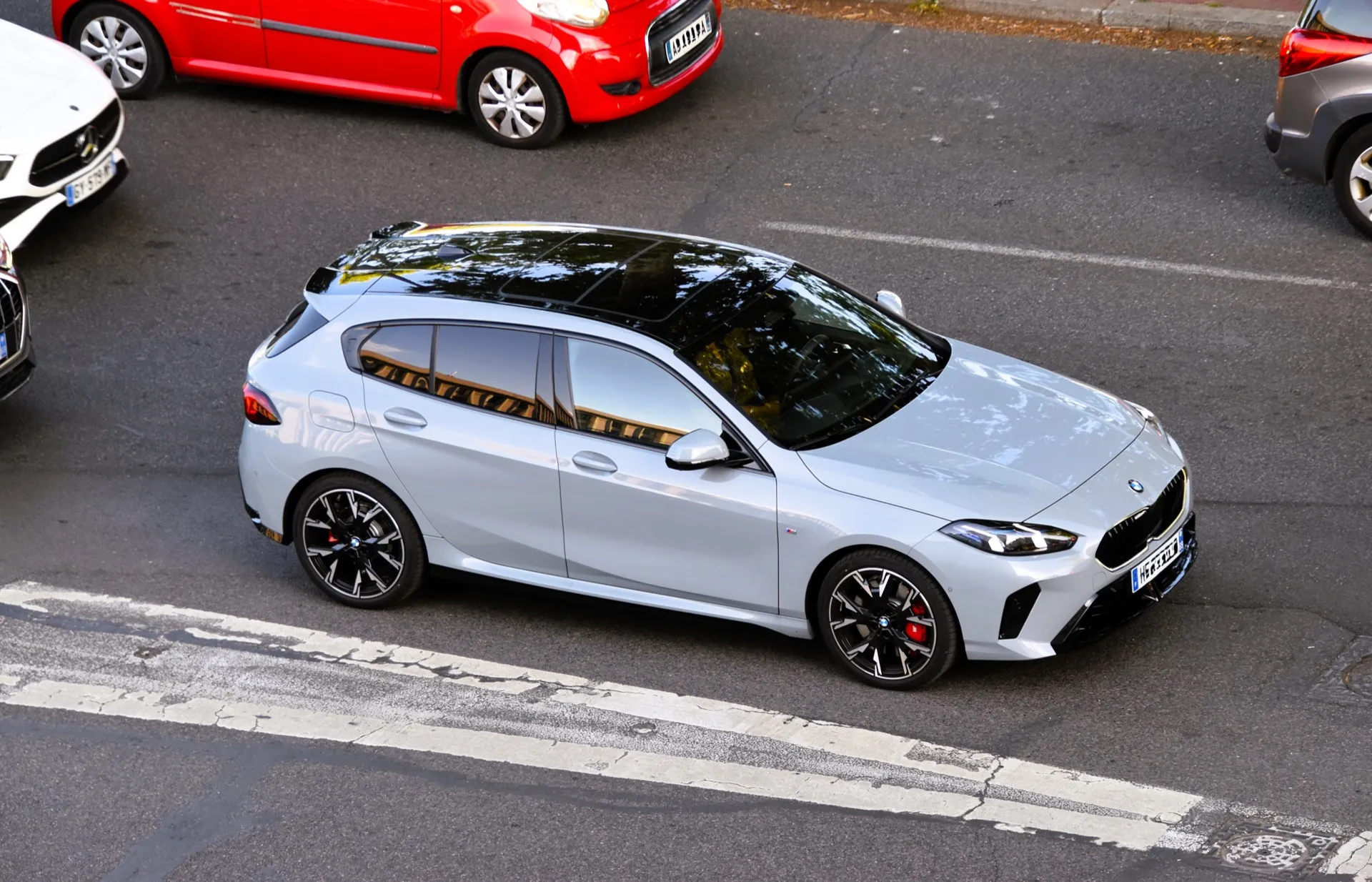 BMW M135 xDrive（F70型）を斜め上から見た外観。ブラックのルーフとレッドのブレーキ・キャリパー