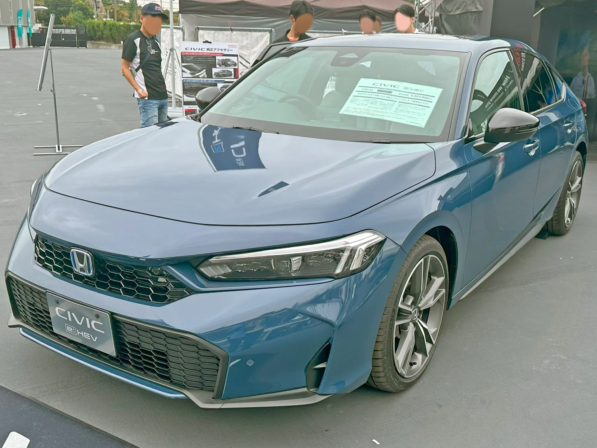 ホンダ シビック e:HEV EX（6AA-FL4）を斜め前から見た外観。ハニカムパターンのフロントアッパーグリル、フルLEDヘッドライト、切削面のある18インチアルミホイール