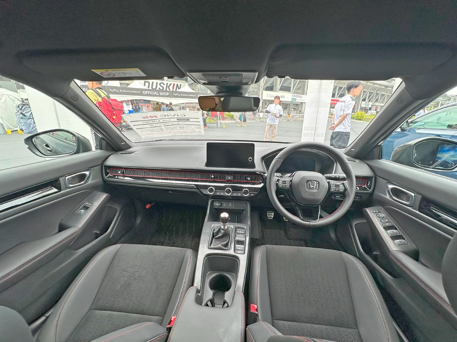 ホンダ シビック RS（5BA-FL1）の運転席まわり。6速マニュアルのアルミシフトノブ、赤ステッチの本革巻ステアリング、赤のピンストライプが入ったハニカム調エアコンアウトレット
