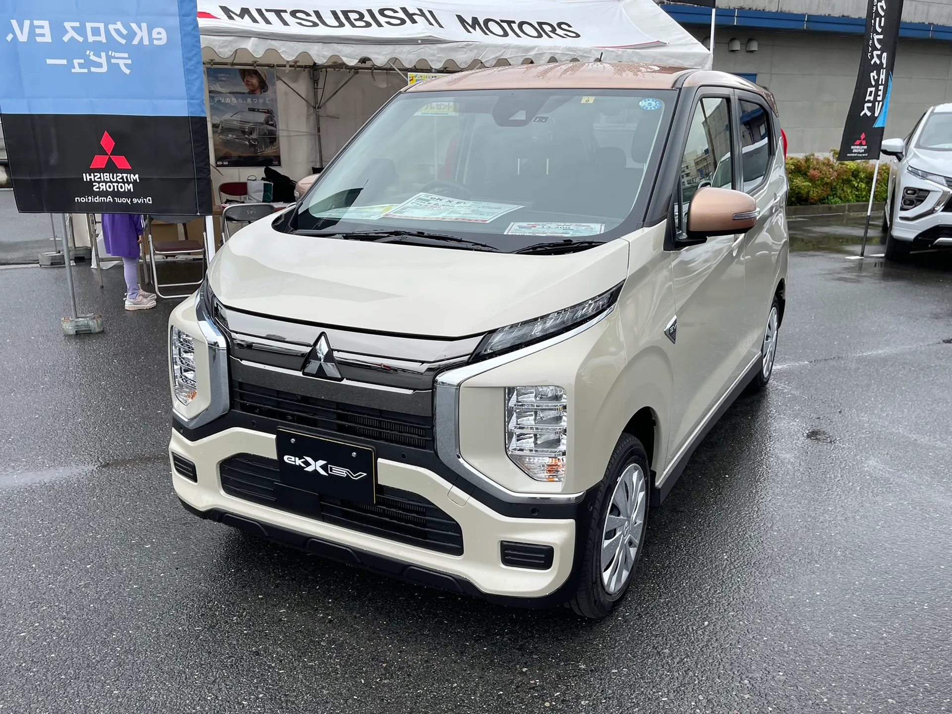 三菱eKクロスEV G(ZAA-B5AW-LDCB)の前方斜め。14インチスチールホイールにフルホイールカバー