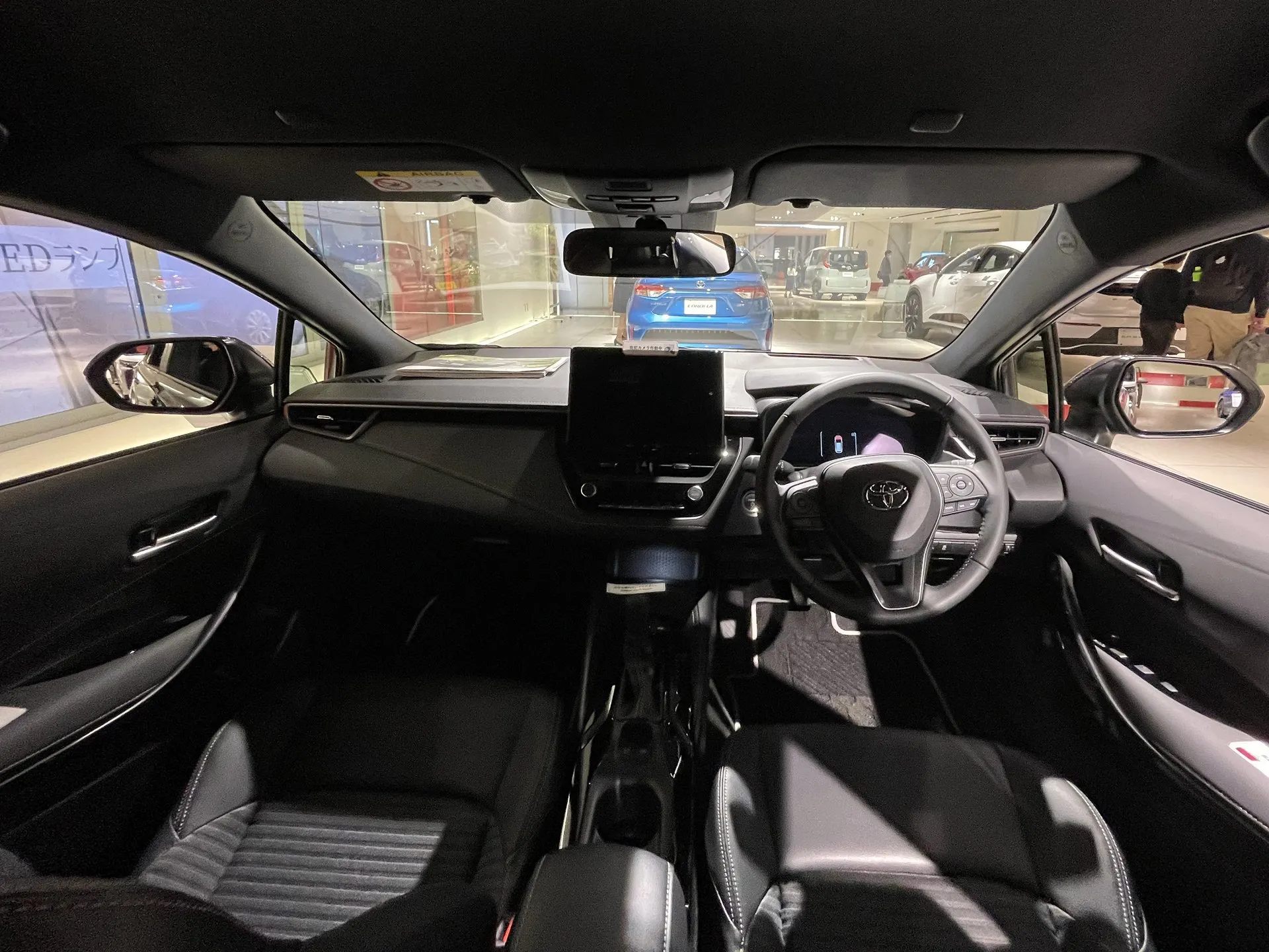 トヨタ カローラ ツーリング ハイブリッド W×B E-Four（6AA-ZWE215W-AWXSB）の運転席まわり。前席の間にセンターコンソールボックスがある