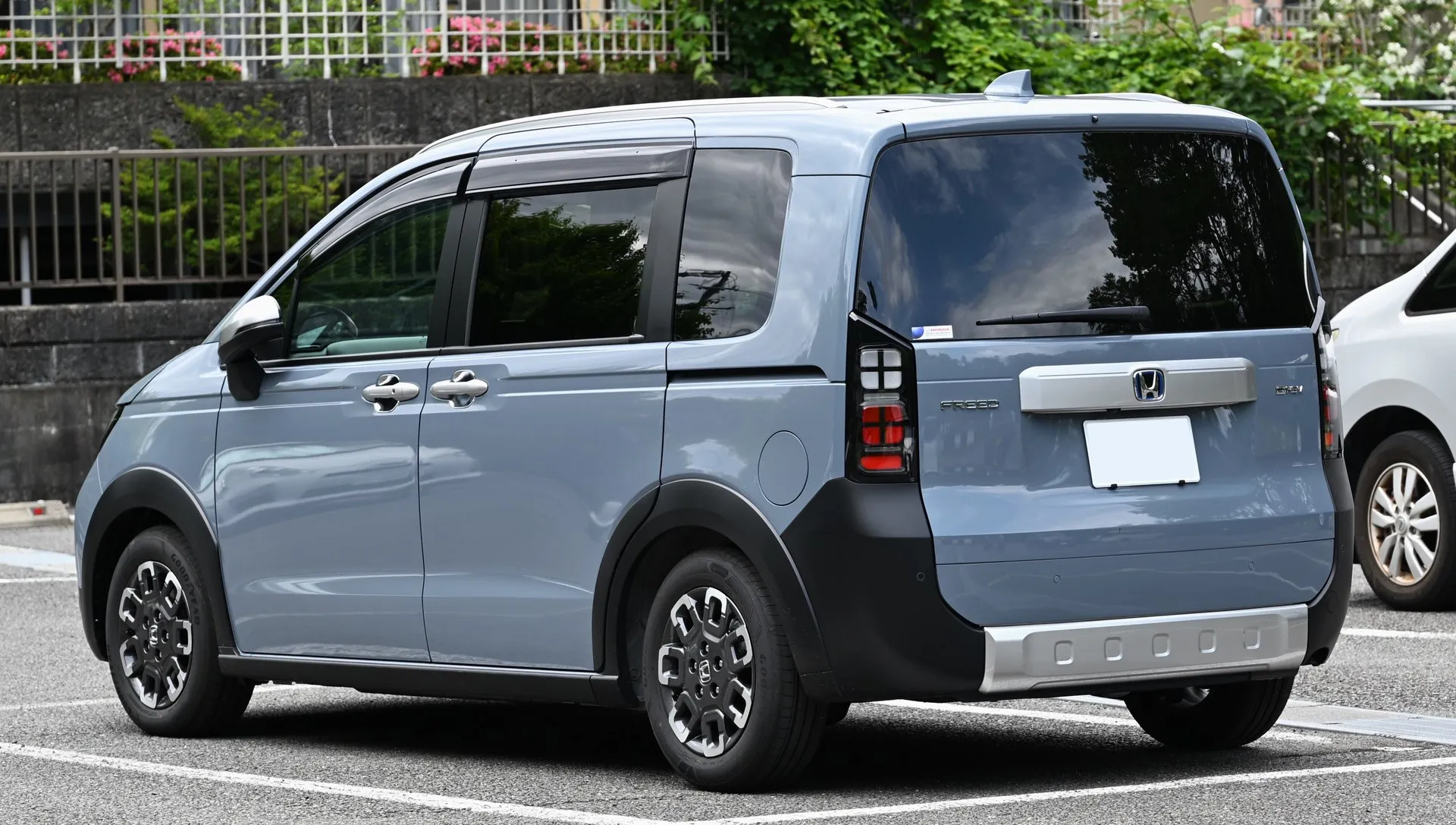 ホンダ フリード e:HEV CROSSTAR を後方斜めから見た外観。テールゲートとリヤバンパーのシルバーガーニッシュが写っている