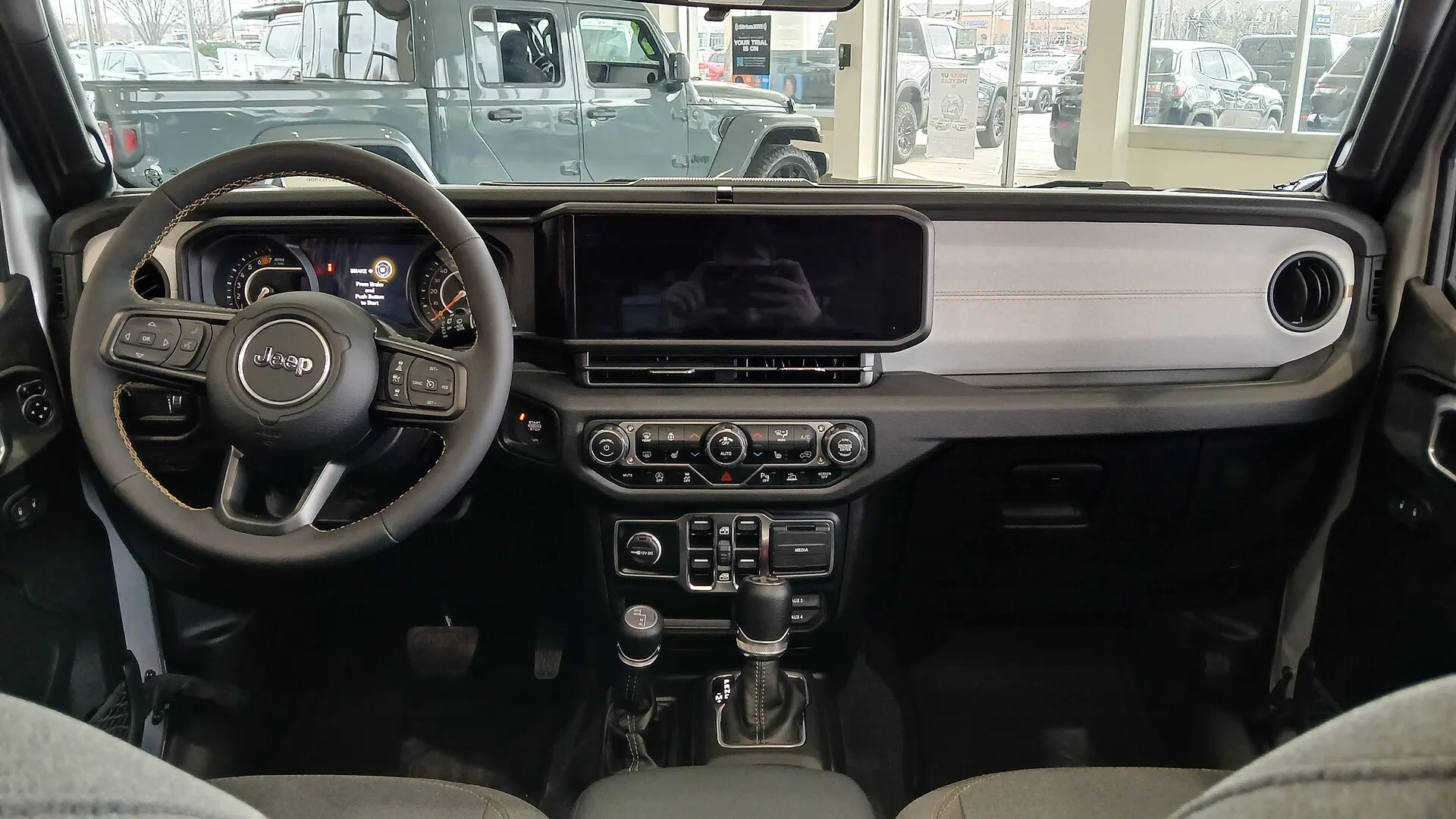 ジープ ラングラー アンリミテッド(JL型)の運転席まわり。12.3インチのタッチパネルモニターの下、シフトレバーの左に副変速機のレバーが立つ