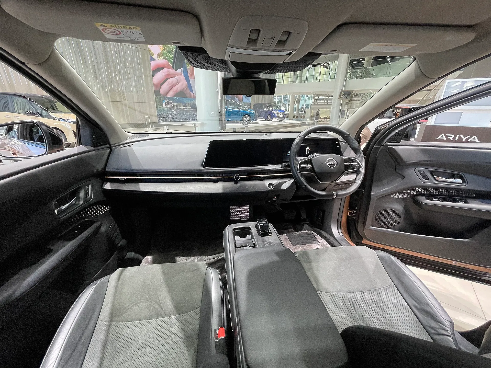 日産 アリア B6（ZAA-FE0）の運転席まわり。スエード／合皮コンビのシートと12.3インチのディスプレイ2枚が並ぶ