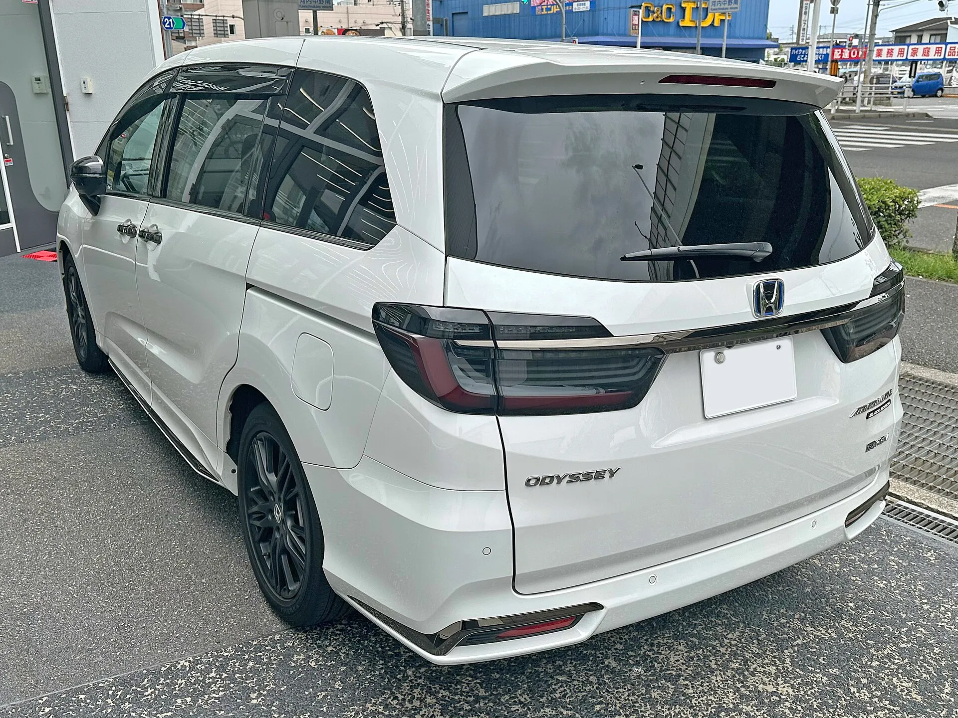 ホンダ オデッセイ e:HEV ABSOLUTE・EX BLACK EDITION（6AA-RC5）を左後方から見た外観。黒いボディにスモークのリアコンビネーションランプが付く