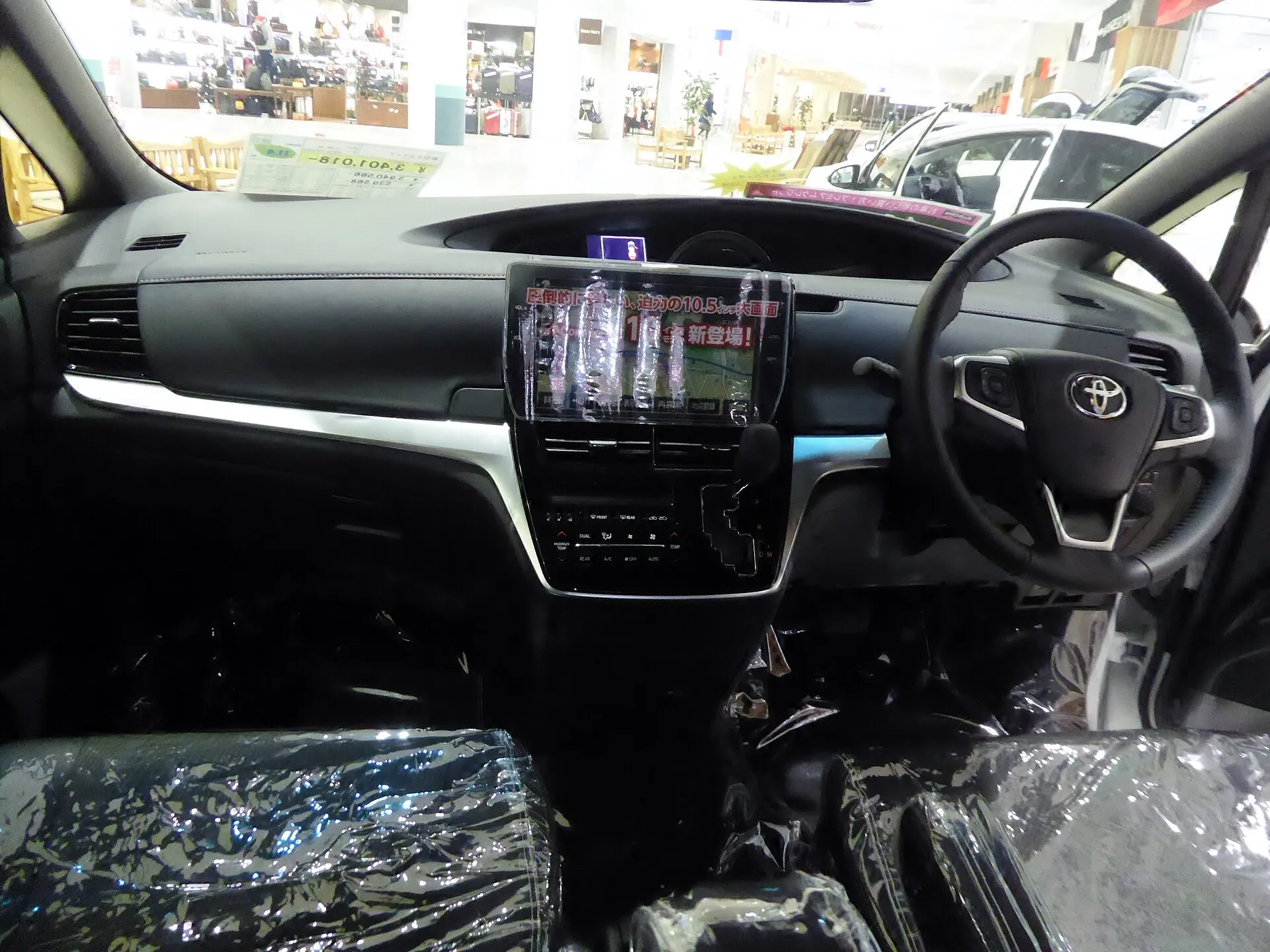 トヨタ エスティマ AERAS PREMIUM（DBA-ACR50W）の運転席まわり。黒い内装で、センターにナビ画面と静電タッチ式のエアコンパネルが並ぶ