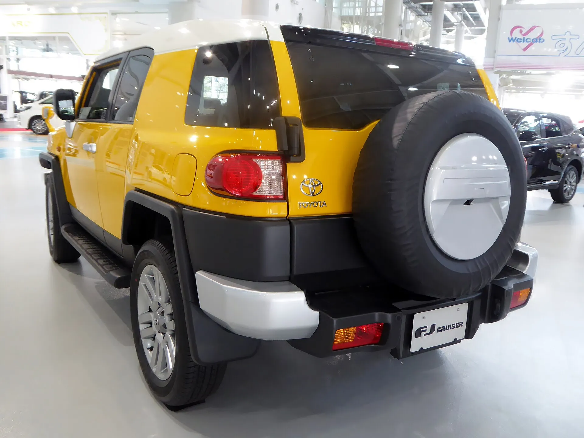 トヨタ FJクルーザー“カラーパッケージ”4WD（GSJ15W）を斜め後ろから見た外観。背面にカバー付きのスペアタイヤ