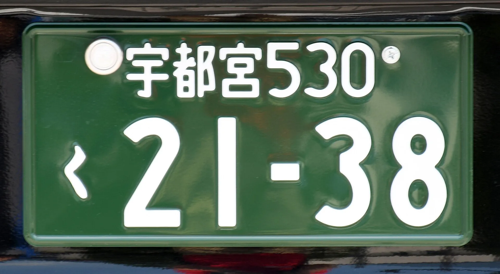 緑地に白い文字のナンバープレートを正面から写した写真。Wikimedia Commons の説明では、排気量660cm3以上の事業用車のものとされている