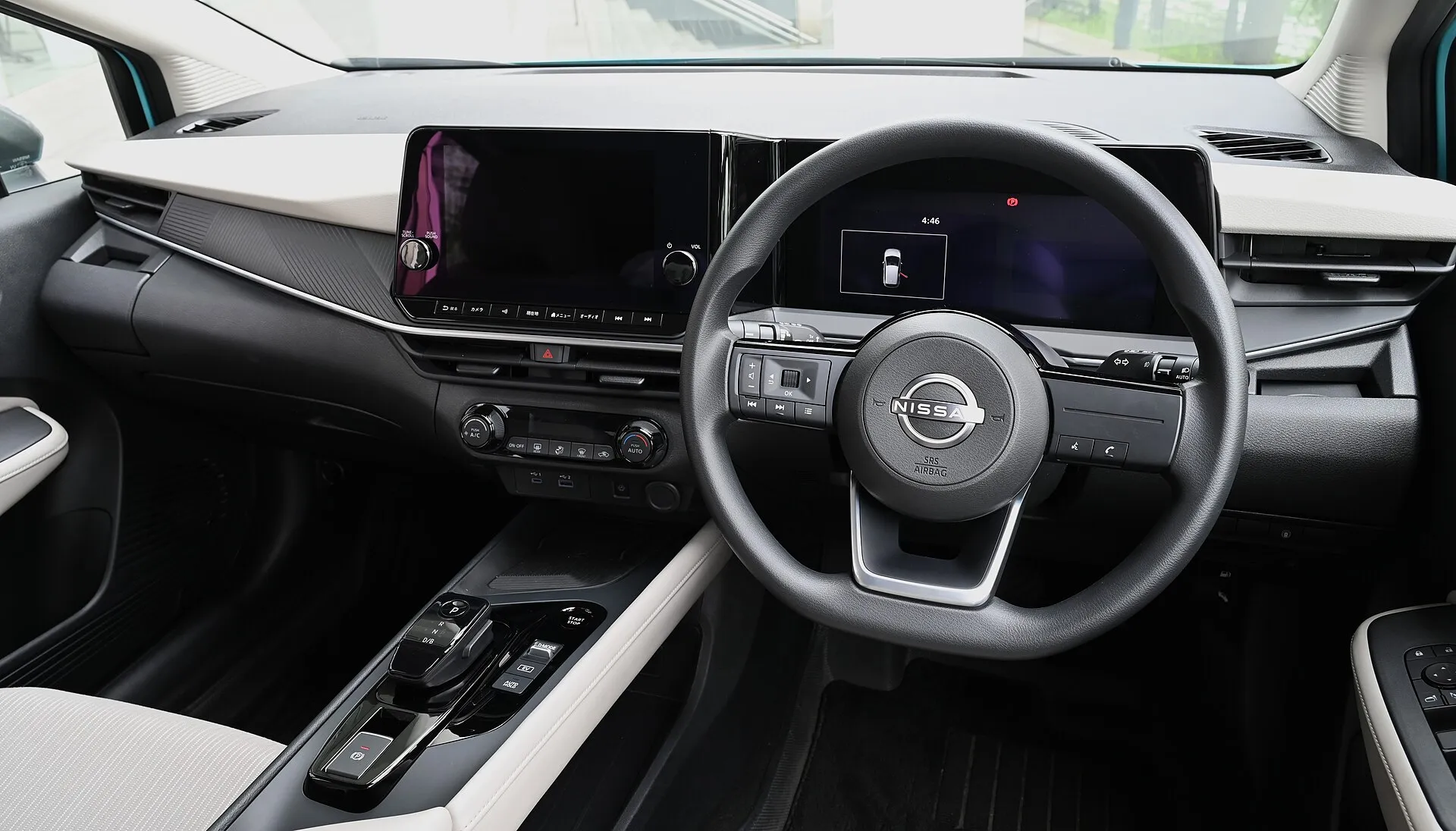 日産 ノート X（E13型）の、2026年8月の一部仕様変更より前の運転席まわり。明るい色のダッシュボードとドアトリムに、黒いステアリングとセンターコンソール