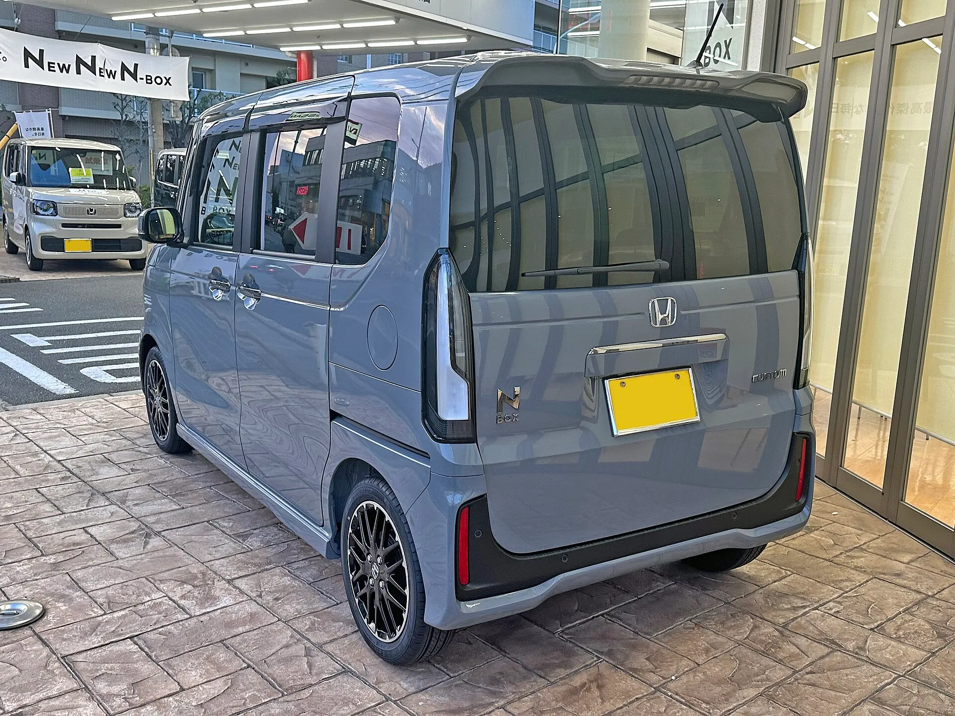 ホンダ N-BOX CUSTOM ターボ コーディネートスタイル（6BA-JF5）を斜め後ろから見た外観。灰色のボディで、2026年7月のマイナーモデルチェンジより前の個体