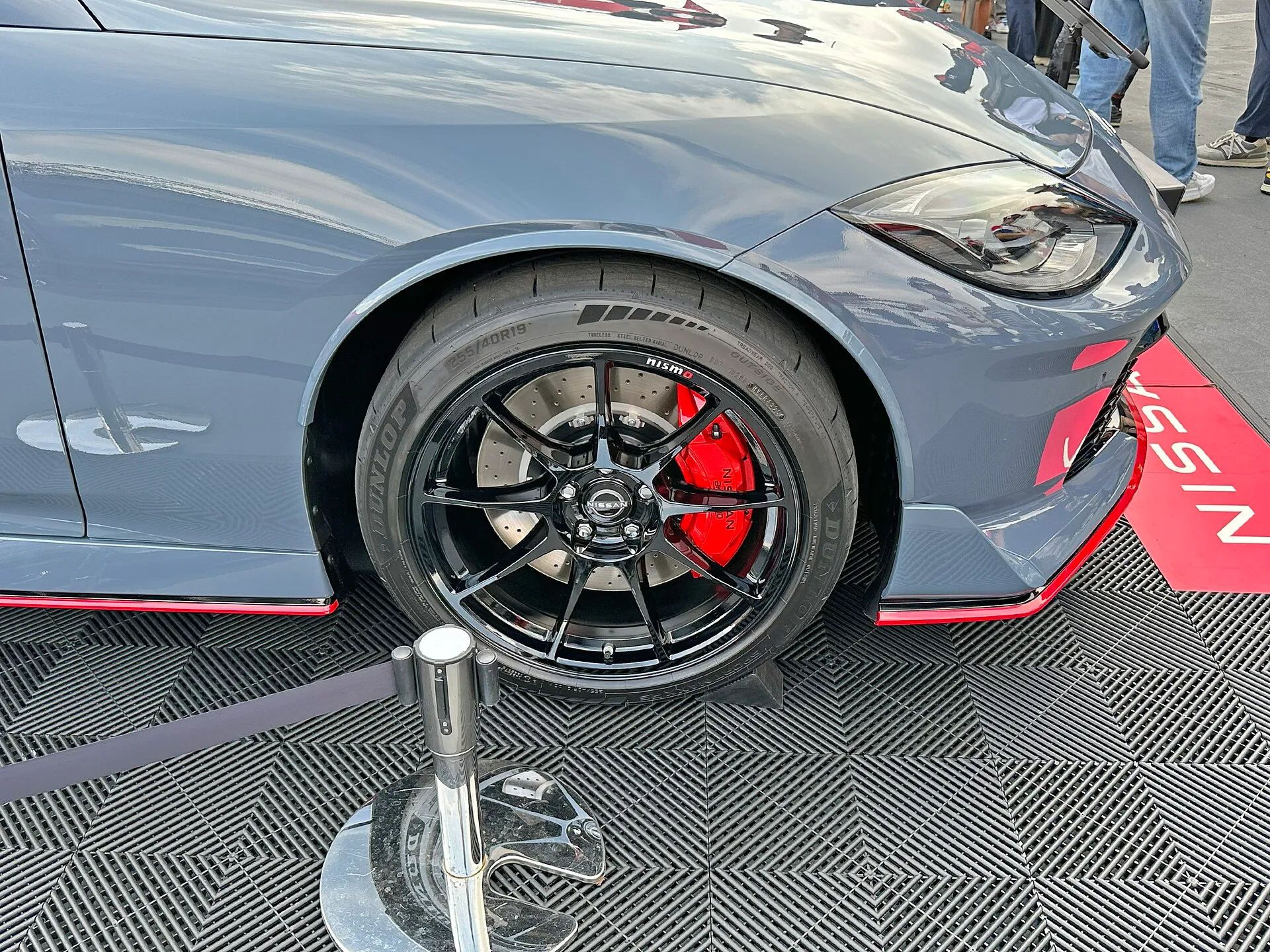 フェアレディZ NISMO 6速MT車の前輪。黒い19インチホイールの内側に、赤いブレーキキャリパーと穴の開いたブレーキローターが見え、タイヤの側面に 255/40R19 の表記がある